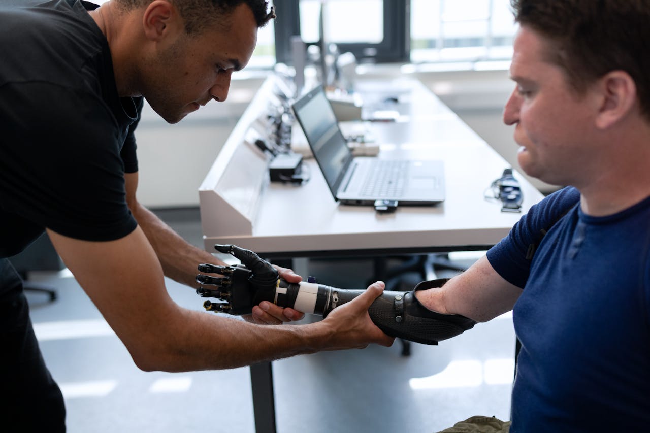 Engineer adjusts prosthetic arm for a patient in a modern lab setting.